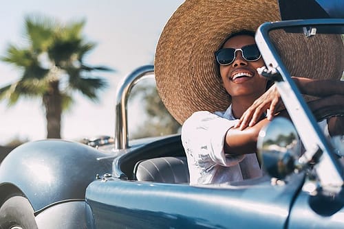 black-woman-driving-a-vintage-convertible-car-BFYH7K3.jpg